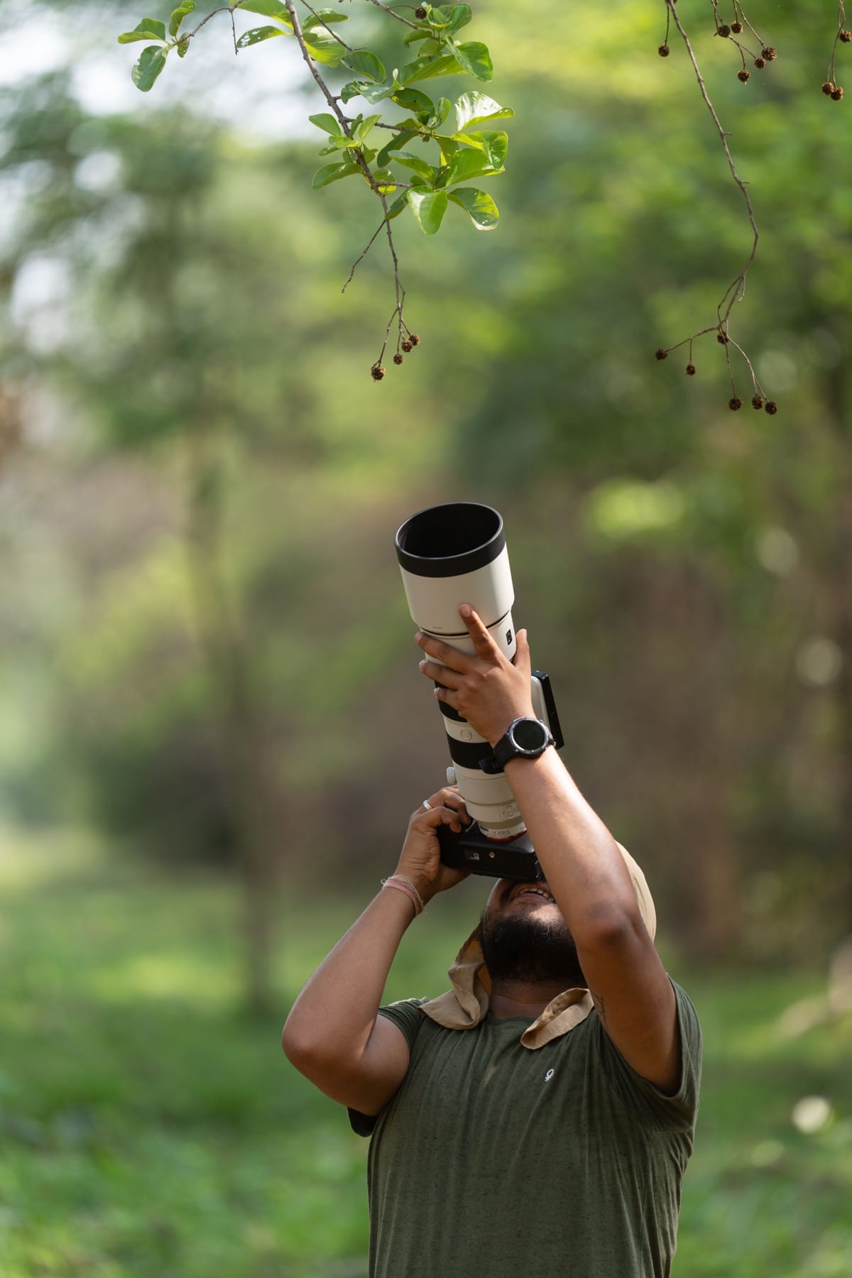 Abhisek Bagaria looking upward through a long lens under forest canopy